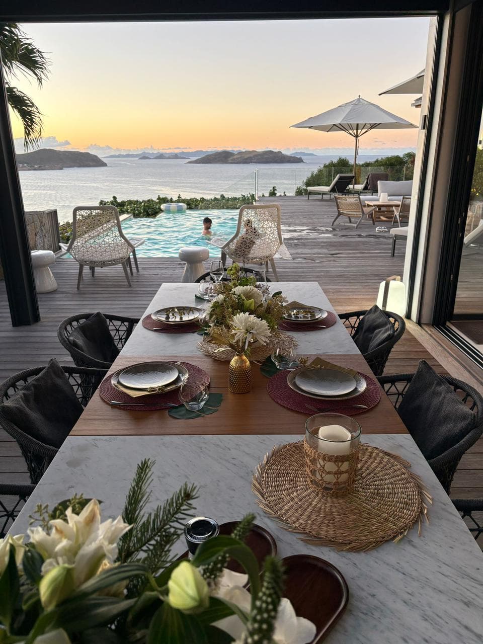Table dressée en terrasse avec vue mer au coucher du soleil